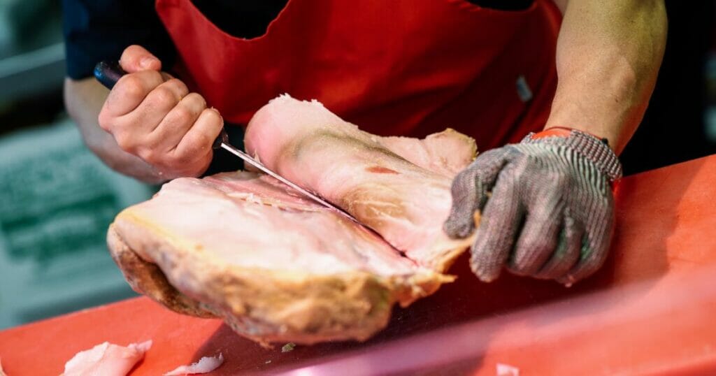 Butcher Boning a Ham in a Modern Butcher Shop